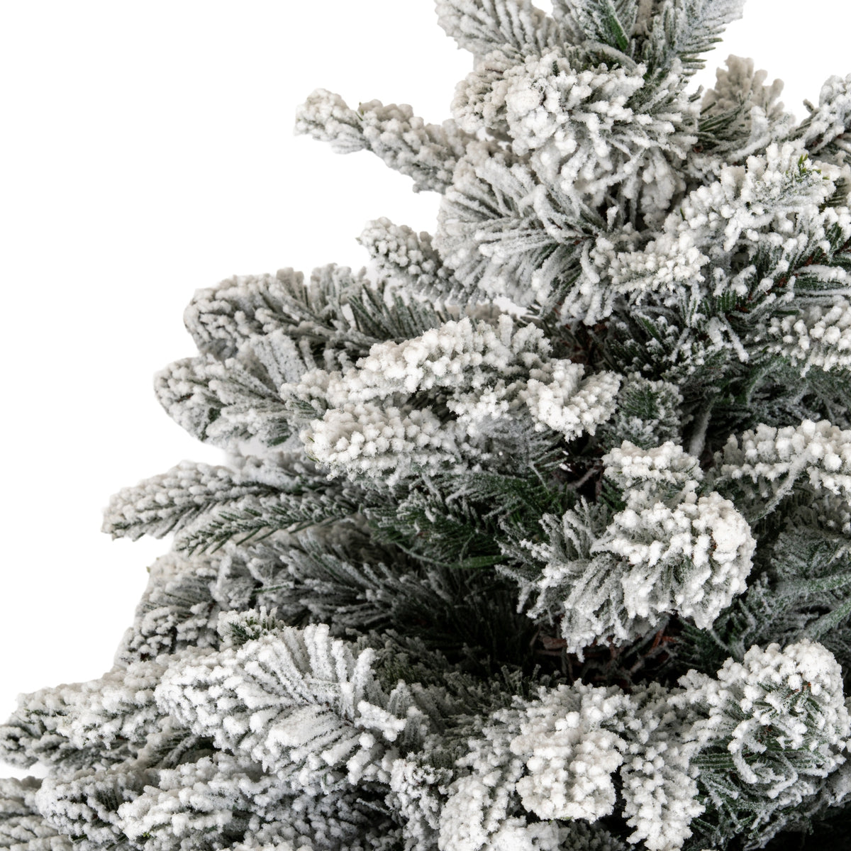 Close-up of dense green artificial fir branches coated with thick, granular white flocking.