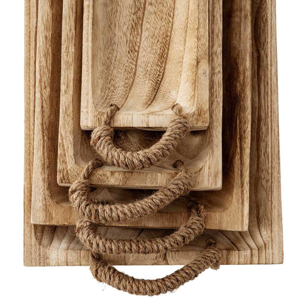 Overhead close-up of nested tray ends, with fibrous wrapped loop handles threaded through paired holes beside flowing grain.