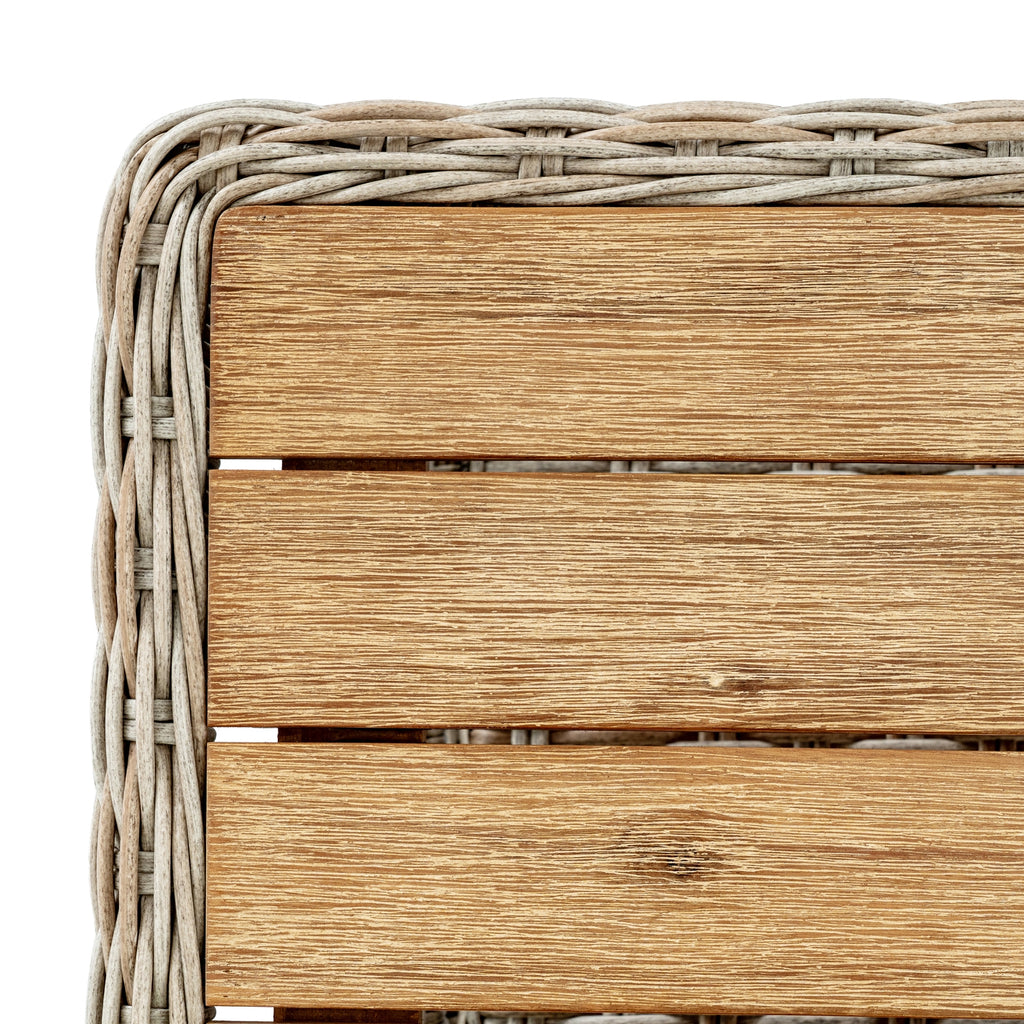 Top corner of the coffee table showing brown slats with pale streaks and a curved woven border.